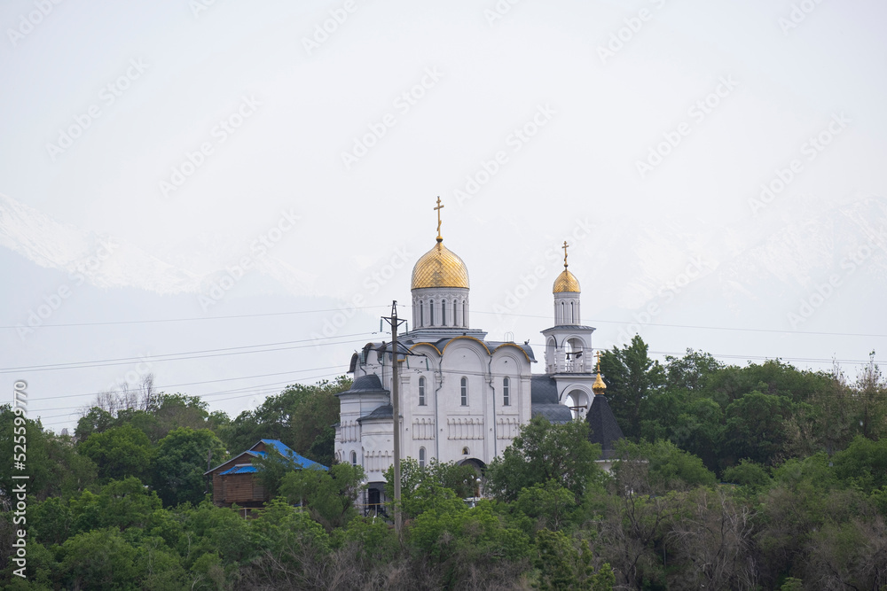Obraz premium Russian Orthodox Church in the middle of the forest. The golden domes of the church rise above the forest.