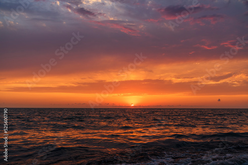 Beautiful sunset over the sea with bright orange clouds.