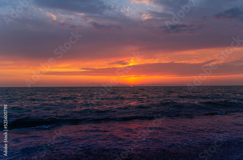 Beautiful sunset over the sea with bright orange clouds.