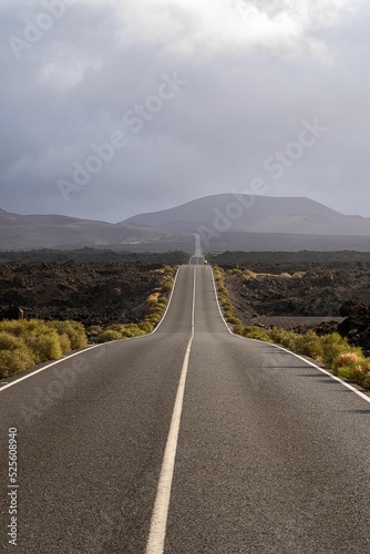 Vertical shot of a road through lava fields of Timanfaya national park, Spain photo