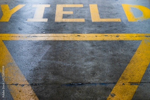 Photography Yellow yield sign at the exit of a car park
