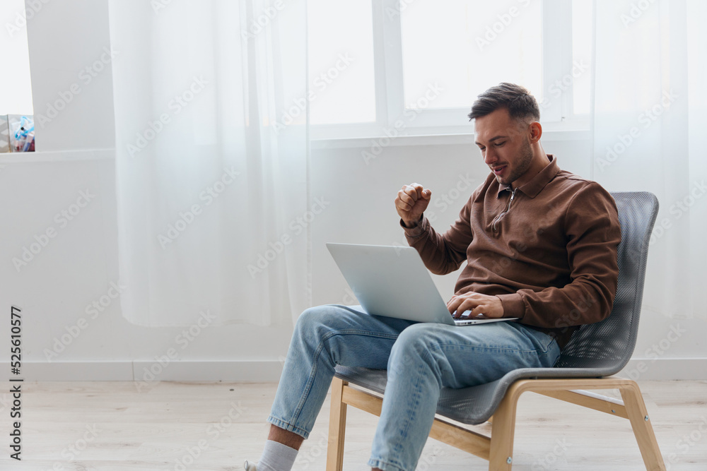 Lucky overjoyed cheerful young tanned man looks at laptop screen celebrating successful project lottery casino win rejoices for victory of national football team sitting on chair at home. Copy space Lucky overjoyed cheerful young tanned man looks at laptop screen celebrating successful project lottery casino win rejoices for victory of national football team sitting on chair at home. Copy space