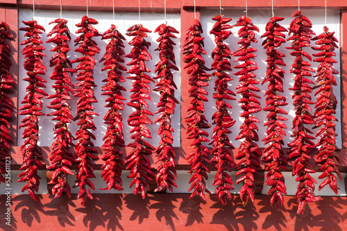 Cordes de piments d'Espelette qui sèchent sur la façade d'une maison basque photo
