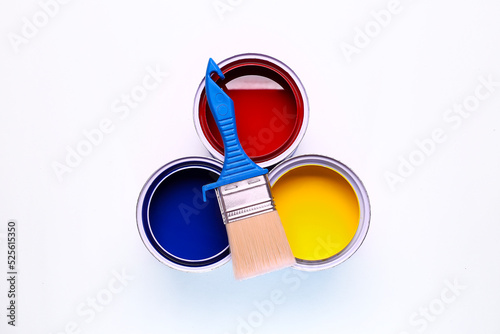 colorful open paint can red blue and yellow brush on it isolated on white background