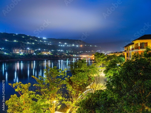 Beautiful scenery of bright green trees in the streets next to a lake in Lavasa at night photo