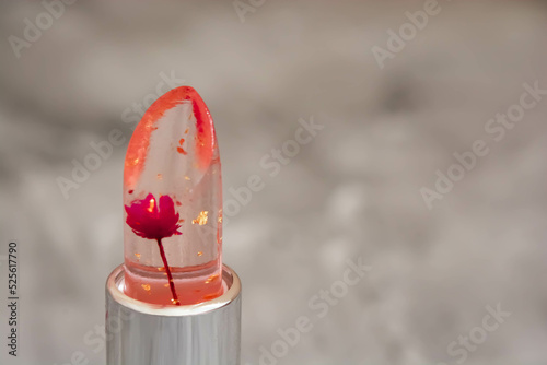 Macro of a lipstick bullet, close-up of lipstick in a silver package on a gray background