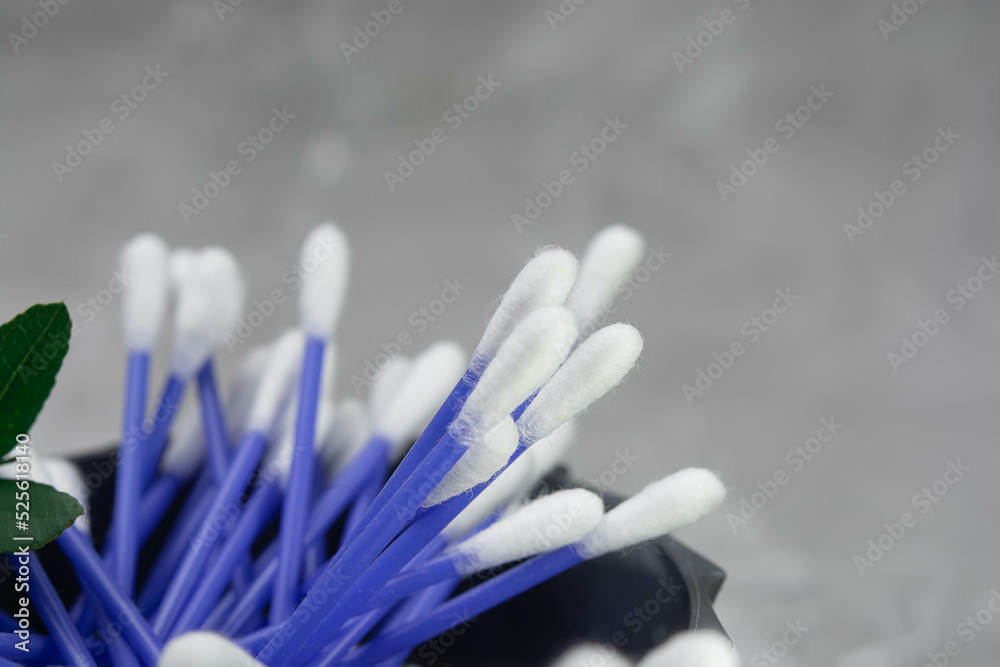 Many cotton buds on a gray background, space for text Many cotton buds on a gray background, space for text