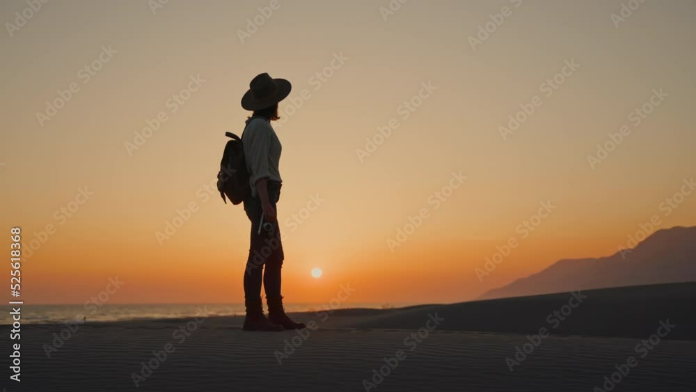 Attractive young girl with a retro camera looking at the mountains against the backdrop of the sun Attractive young girl with a retro camera looking at the mountains against the backdrop of the sun