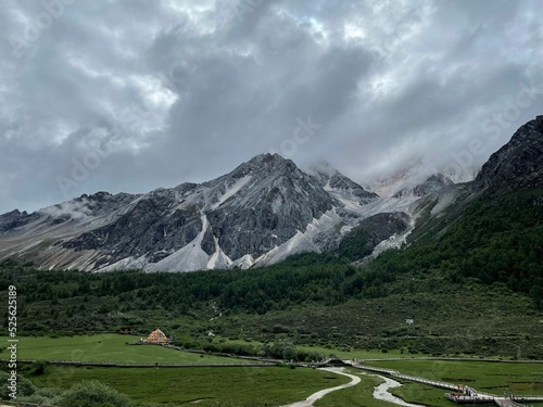 Beautiful scenic view of rocky mounatins near a green valley with photo