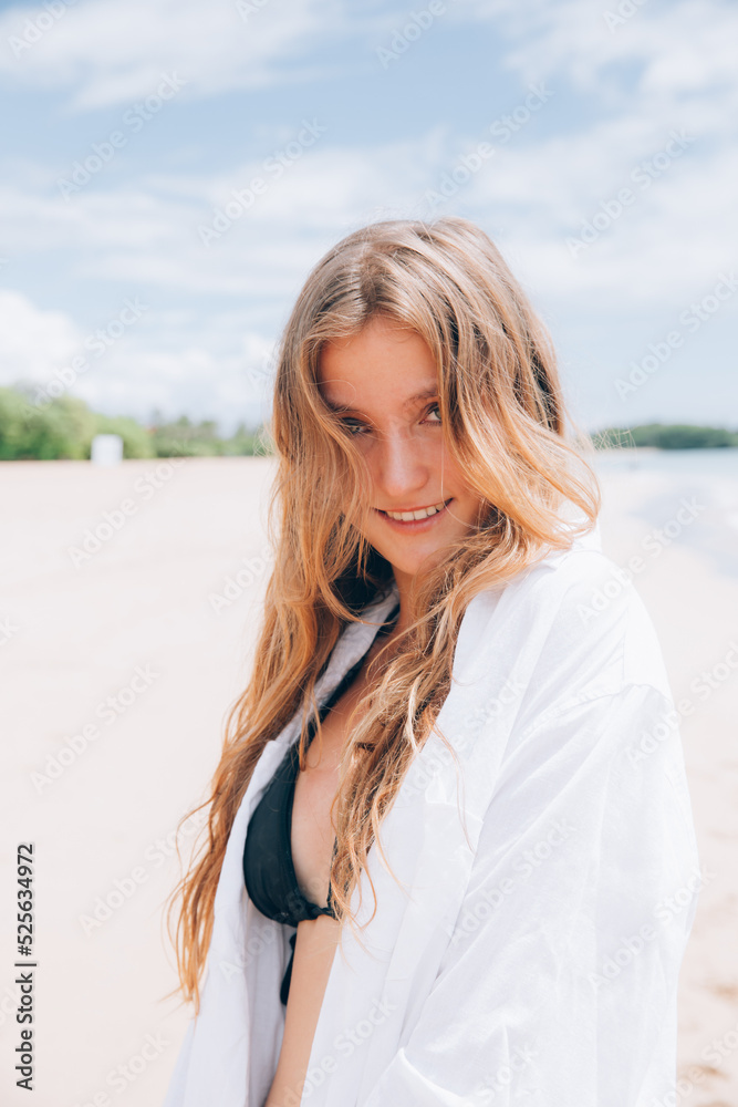 portrait of young beautiful blonde woman enjoying life on white sand beach