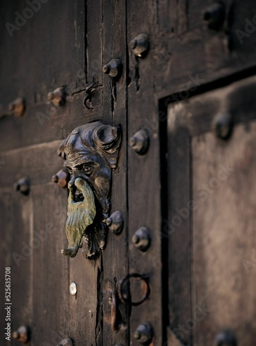 Closeup shot of a beautiful door knocker with man's face in the historic center of Cartagena city photo