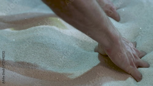 Hands Digging Sand in interactive Sandbox With Projected Sealife