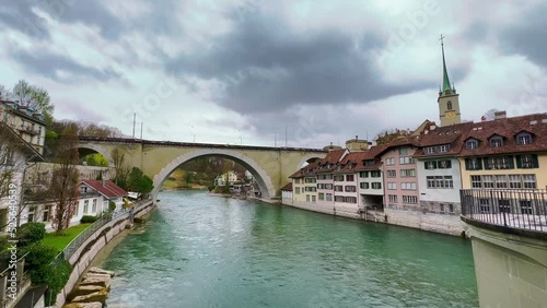 The arched stone Nydegg Bridge across River Aare with historic houses on its banks, Bern, Switzerland photo