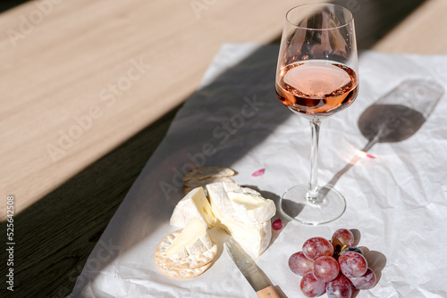 Fototapeta Naklejka Na Ścianę i Meble -  A glass of rose wine with appetizers on a white background.