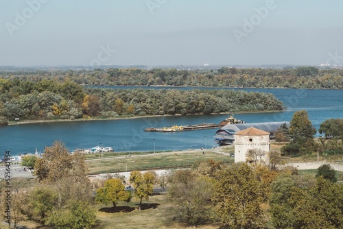 High angle shot of a small tower and forests on the bank of a river in Belgrade photo