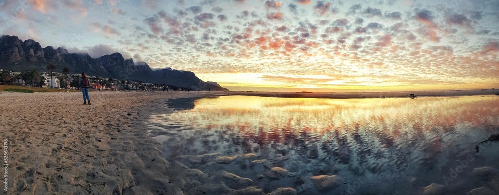 Fototapeta premium Beautiful Camps bay beach in cape town, south Africa under reflecting sunset sky on the water