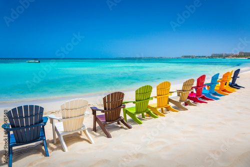 Fototapeta Naklejka Na Ścianę i Meble -  Idyllic beach with rustic adirondack chairs in Aruba, Dutch Antilles
