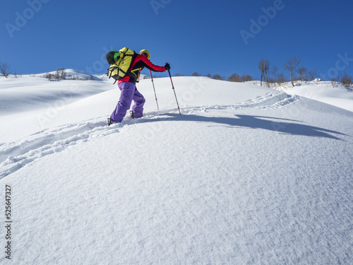 Active man ski touring on mountain skis or splitboard at winter day photo
