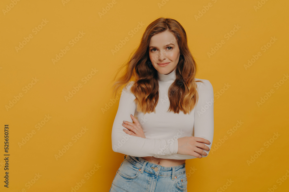 Charming lovely woman keeping hands crossed and looking at camera with kind smile on face Charming lovely woman keeping hands crossed and looking at camera with kind smile on face