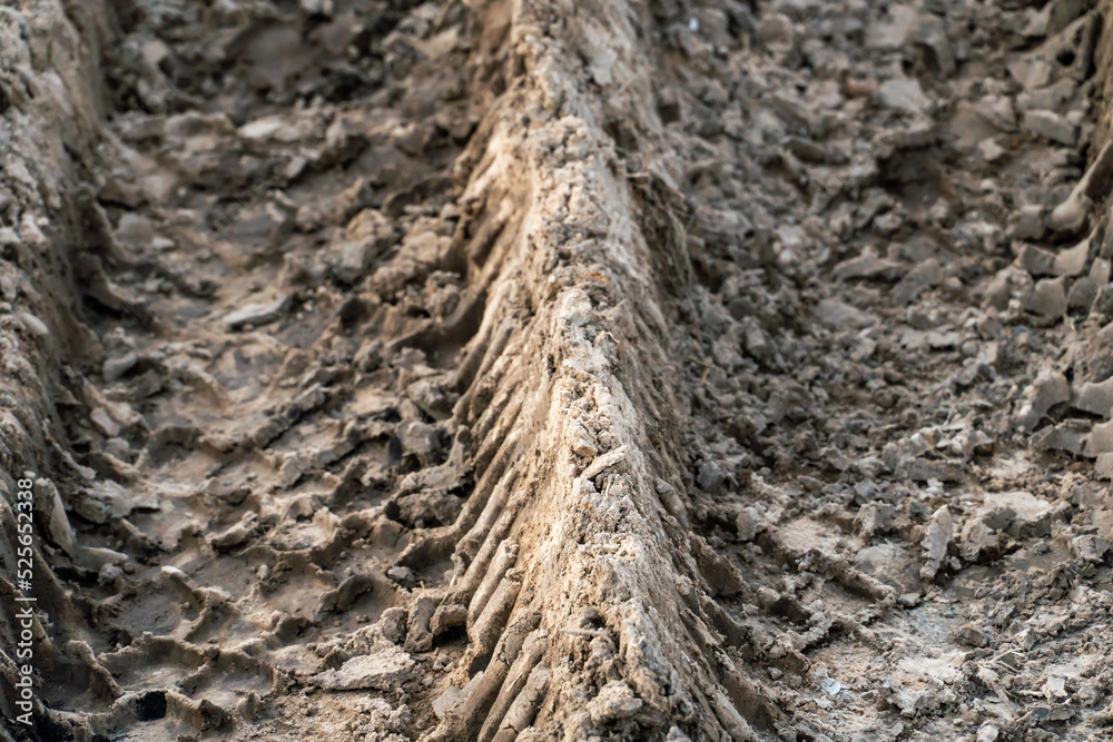 A deep car track on a Russian dirt road after rain. The imprint of car tires on the dirt. Dried mud on the roads in the village. A deep car track on a Russian dirt road after rain. The imprint of car tires on the dirt. Dried mud on the roads in the village.