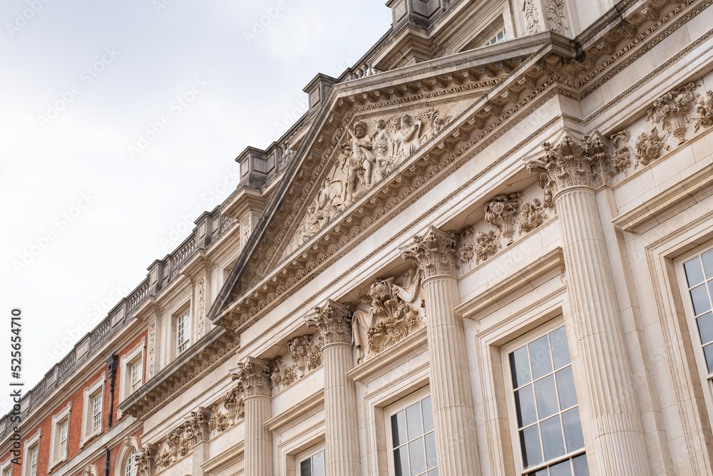 facade of a building palace windows columns relief tympanum hampton court london england 