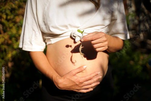 Pregnant woman with a sprouted plants is expecting