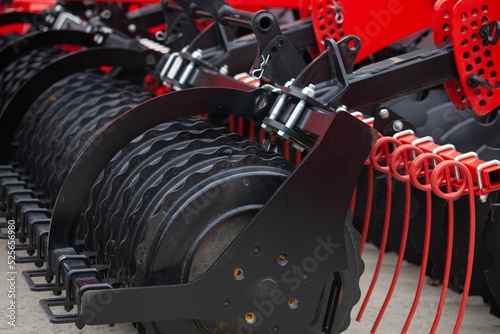 Closeup shot of a red stubble cultivator on a sunny day