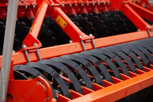Closeup shot of an orange stubble cultivator on a sunny day