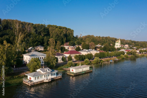 Embankment of town on banks of Volga with buildings on hillside hidden in dense foliage Plyos Russia