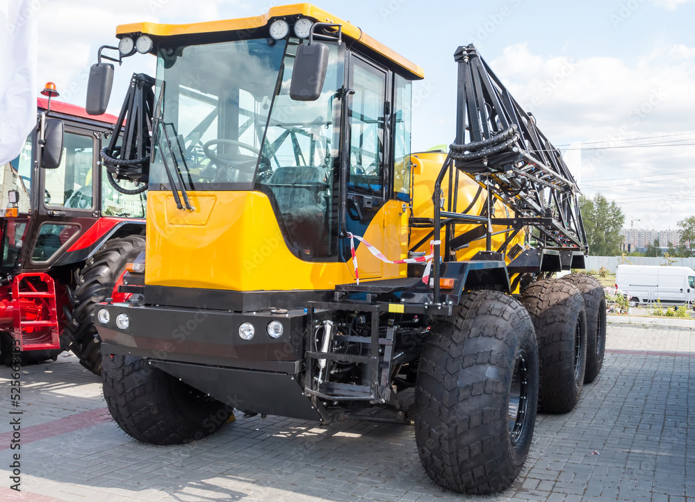 Yellow agricultural all-terrain vehicle with field spraying equipment