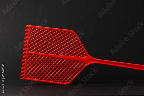 Close-up shot of red fly swatter isolated on black background