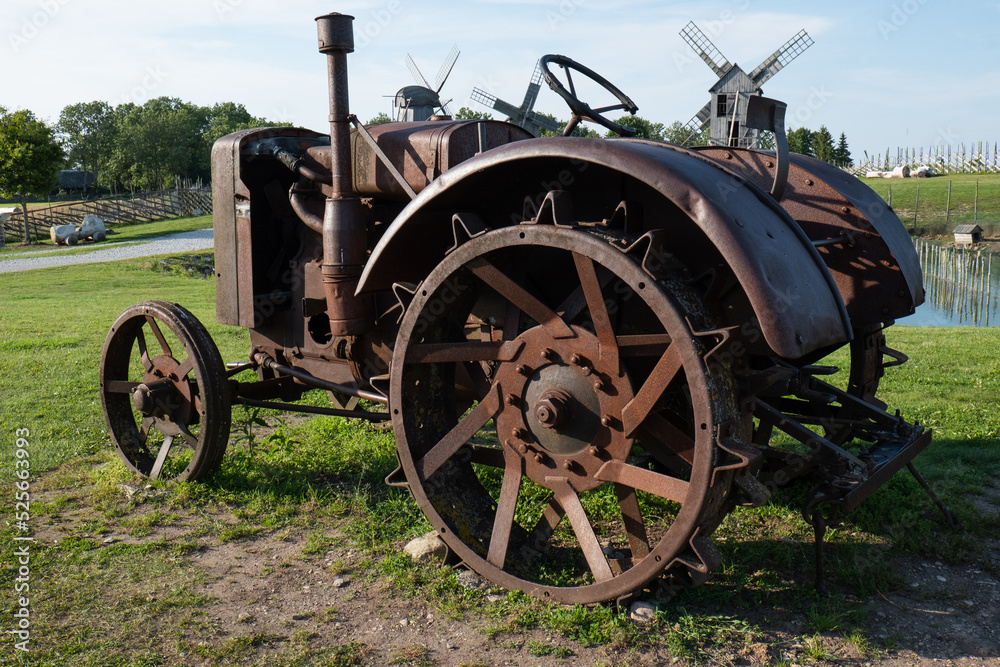Broken rusty tracktor. Old vintage tractor or agricultural vehicle out for display.