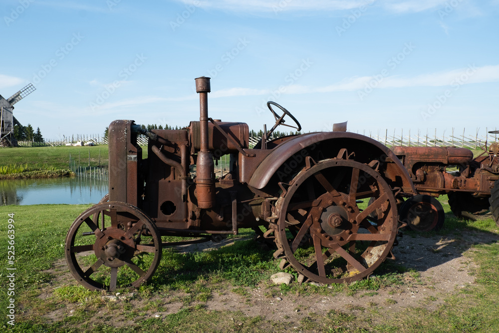 Broken rusty tracktor. Old vintage tractor or agricultural vehicle out for display.
