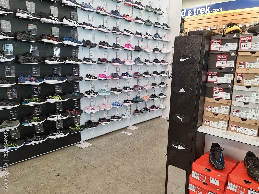 Duży sklep w galerii handlowej z butami sportowymi. StockFoto Adobe