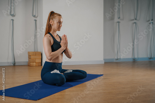 a woman doing Pilates yoga stretching in the studio. Hands folded in namaste