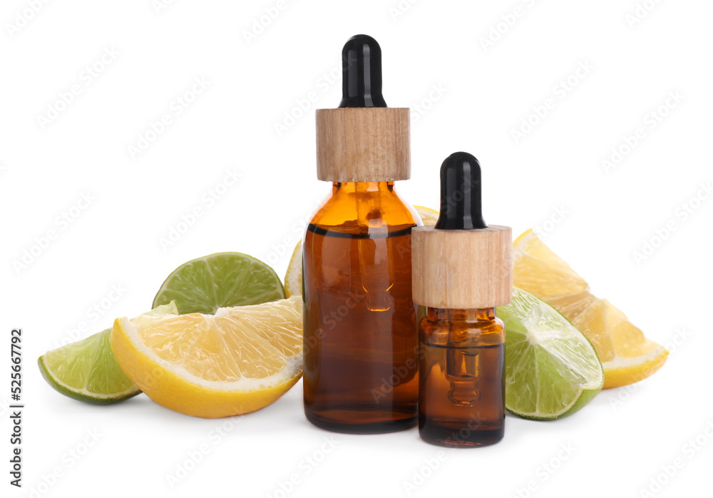 Bottles of citrus essential oil and cut fresh fruits isolated on white Bottles of citrus essential oil and cut fresh fruits isolated on white