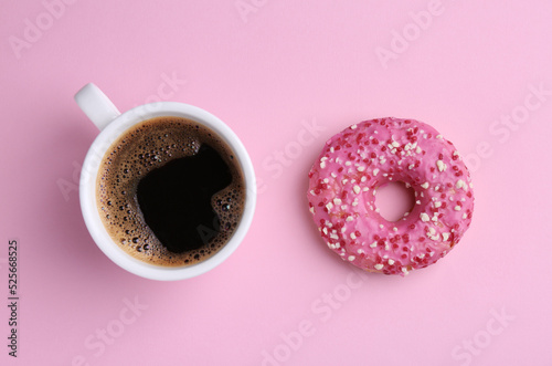 Tasty donut and cup of coffee on pink background, flat lay photo
