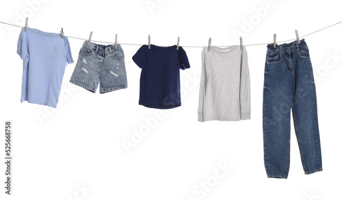 Different clothes drying on washing line against white background photo