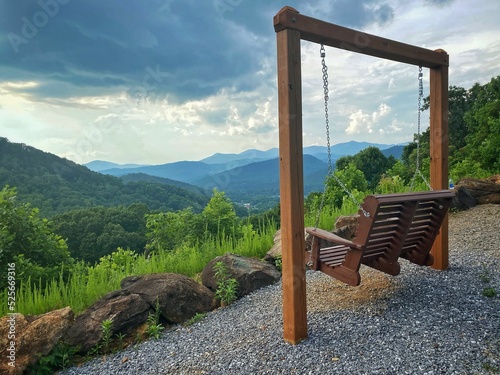 Wooden porch swing with a beautiful mountainous landscape view in a rural area photo