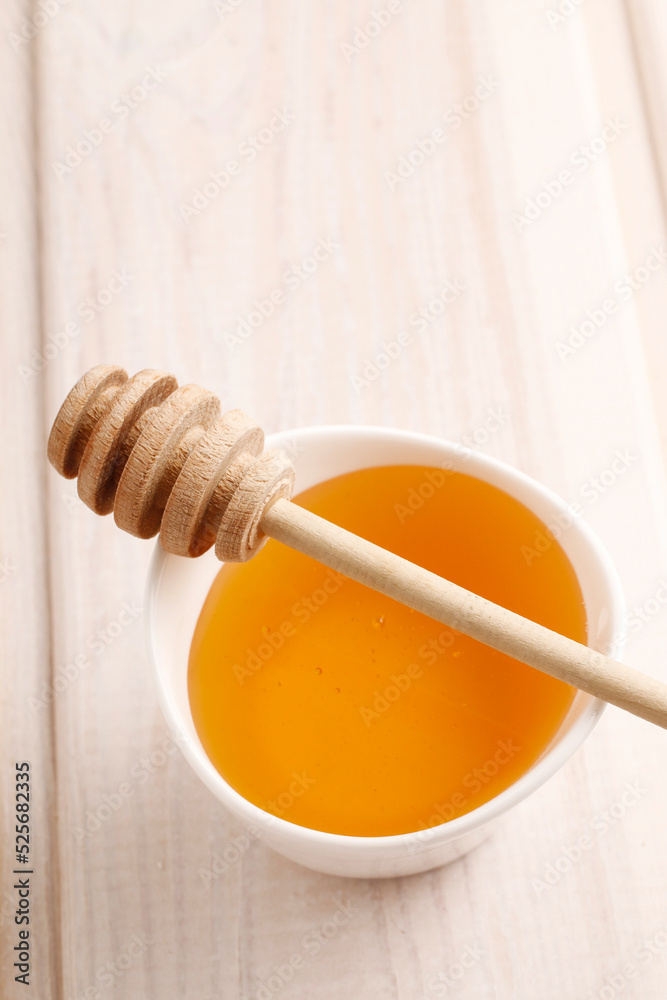 Bowl of honey on wooden table. Symbol of healthy living and natural medicine. Aromatic and tasty Bowl of honey on wooden table. Symbol of healthy living and natural medicine. Aromatic and tasty