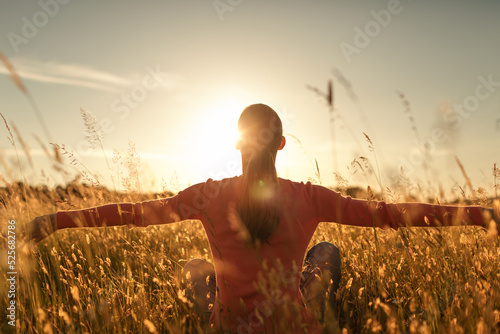 It's a beautiful life. Happy woman sitting a field at sunrise 