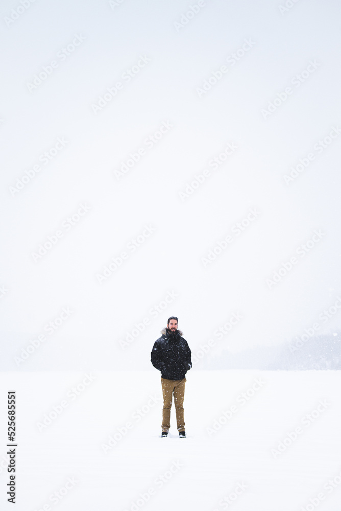 Young man isolated in nature during snowy winter day