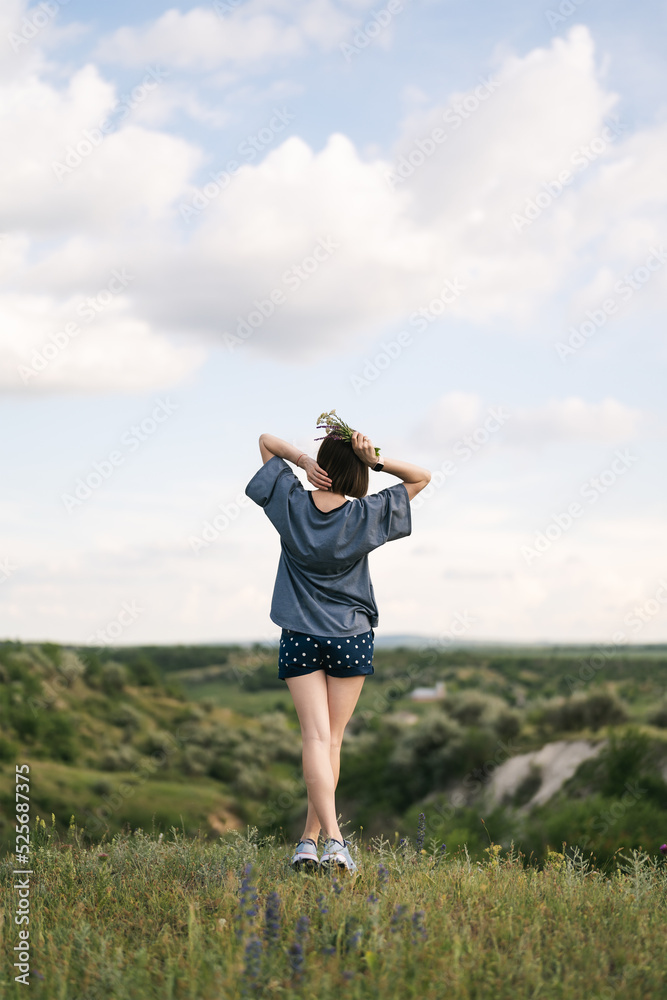 Carefree young woman daydreaming in nature with beautiful clouds in background Carefree young woman daydreaming in nature with beautiful clouds in background
