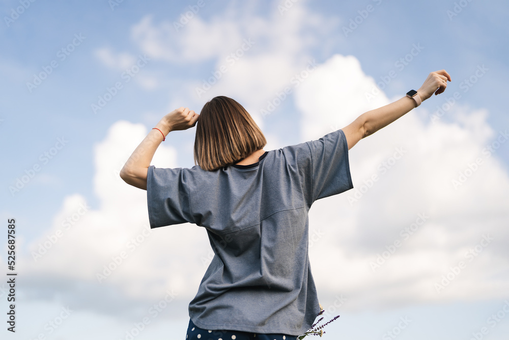 Carefree young woman daydreaming in nature with beautiful clouds in background Carefree young woman daydreaming in nature with beautiful clouds in background