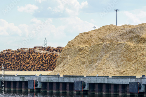 a large pile of wood chips and a huge ridge of logs in the port area