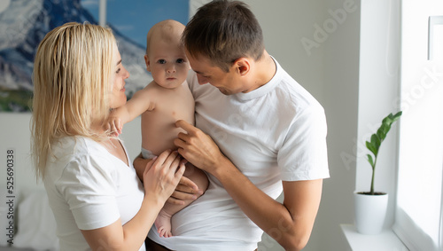 A Happy young family with baby in white bedroom