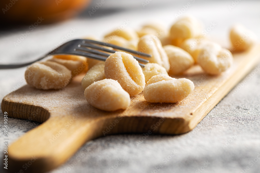 Uncooked potato gnocchi on cutting board. Tasty italian food.