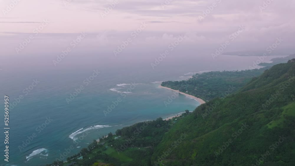 Grassy area for recreation and camping behind the Haena beach. Aerial view of a crescent shaped bay fringed by palm trees and purple sunset skyline above. High quality 4k footage Grassy area for recreation and camping behind the Haena beach. Aerial view of a crescent shaped bay fringed by palm trees and purple sunset skyline above. High quality 4k footage