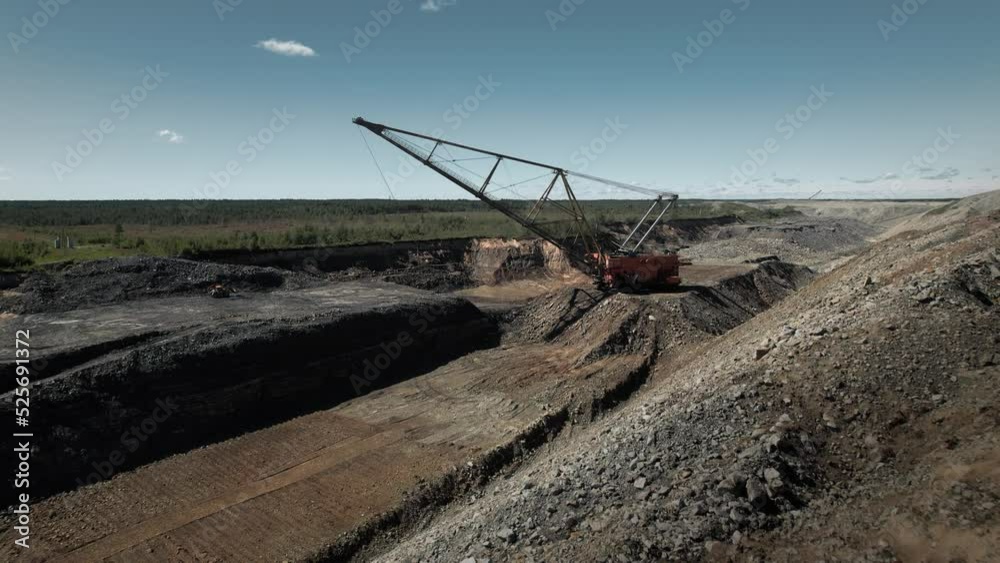 Huge dragliner excavator mining gold in an open pit. Aerial industrial quarry scene. Pollution, environment and ecology concept Huge dragliner excavator mining gold in an open pit. Aerial industrial quarry scene. Pollution, environment and ecology concept
