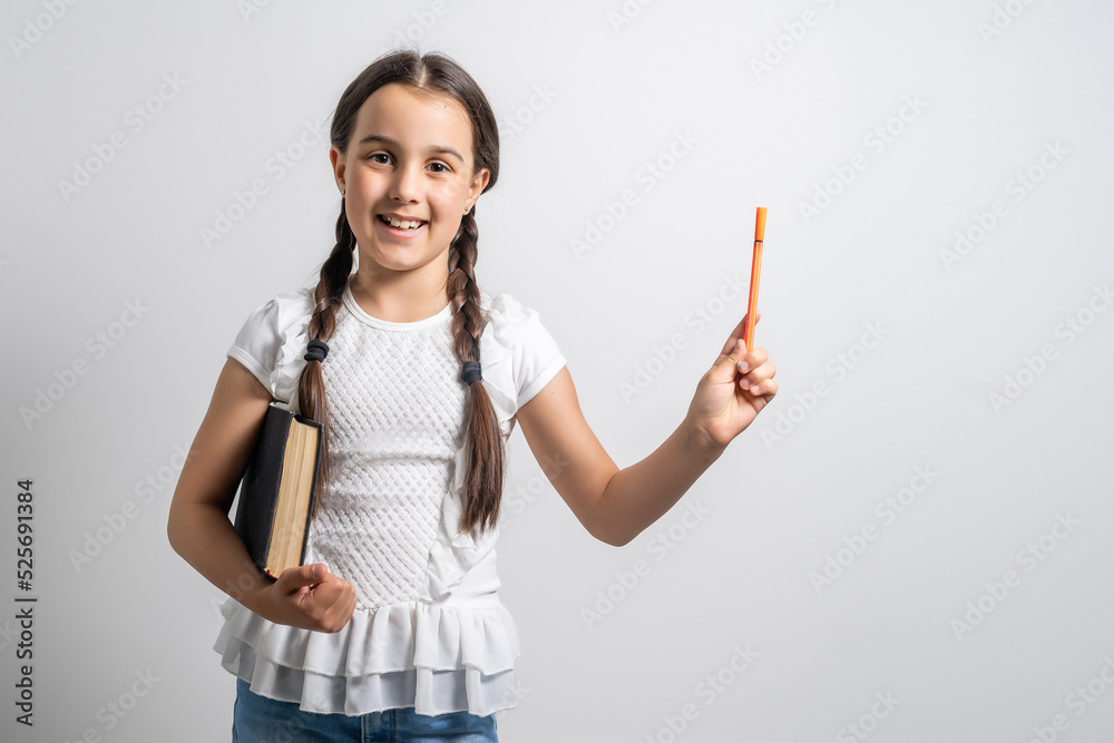 Lovely little girl standing and holding book over white background